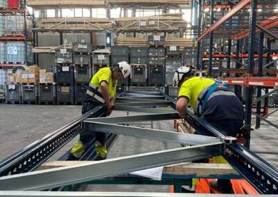 Montaje de estanterías metálicas convencionales en almacén industrial